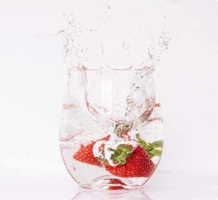 水が入ったコップにイチゴが落ちる